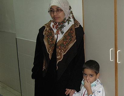 Mother holding her sons hand in the hospital
