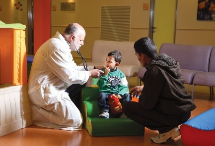 a doctor checking a child next to a family member